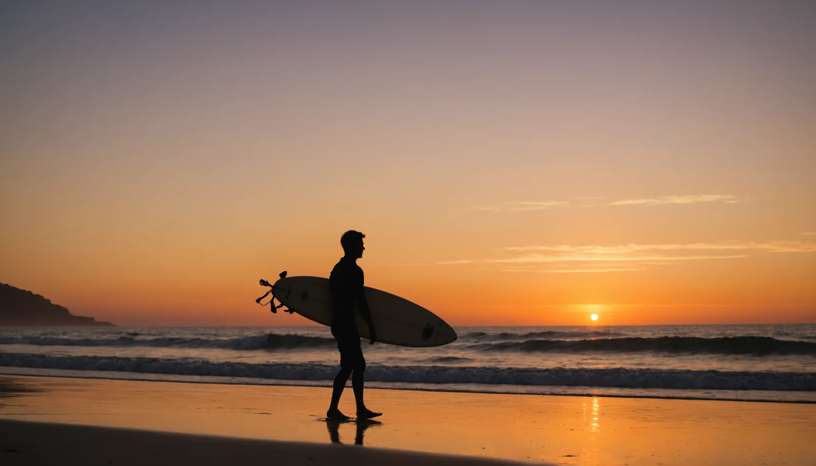Portrait of a surfer carrying a board along a beach at sunset, silhouette against the orange sky.